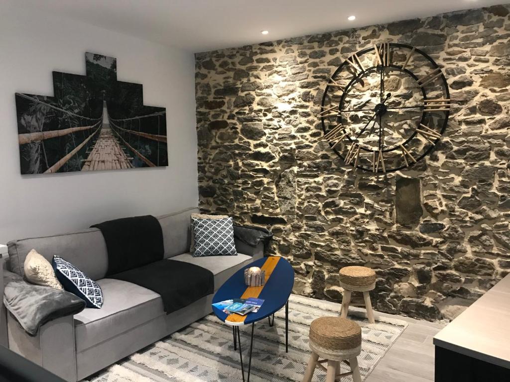 un salon avec un canapé et un mur en pierre dans l'établissement O’Bon Secours, à Saint-Malo