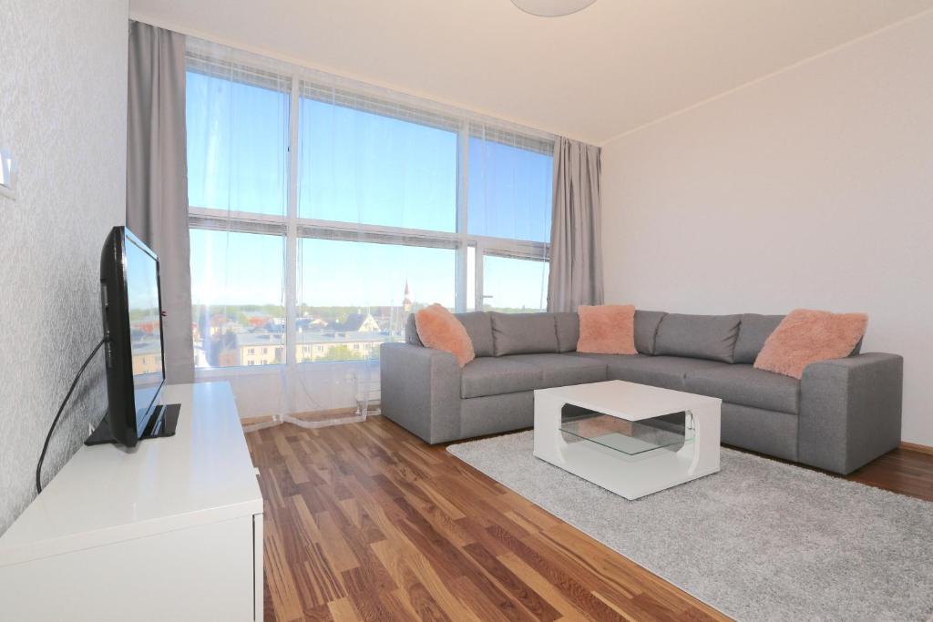 a living room with a couch and a tv at Lys Apartments City Center in Pärnu