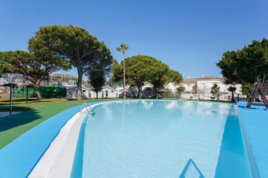 una grande piscina in un parco alberato di La Almadraba a Chiclana de la Frontera