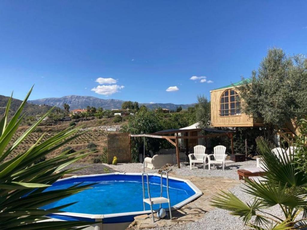 a swimming pool in a yard with a house at Treehouse ,Casa Arbol, with Spa in Algarrobo