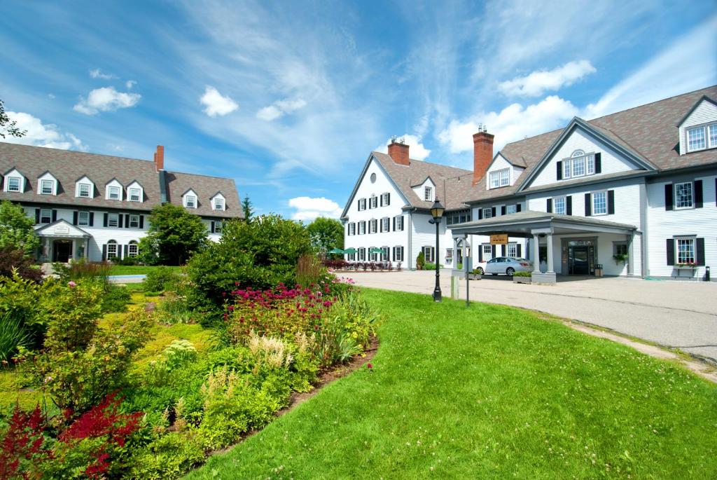 une rangée de maisons blanches avec une cour verte dans l'établissement The Essex Resort & Spa, à Burlington