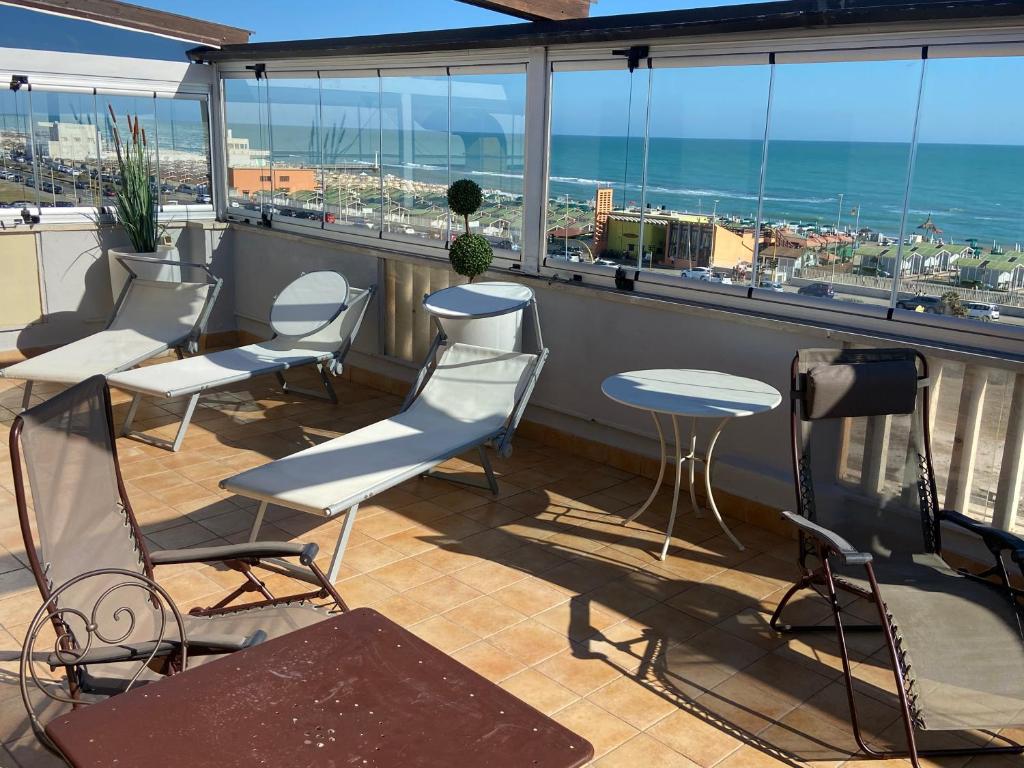 a balcony with chairs and tables and a view of the ocean at Hotel Bellavista in Lido di Ostia