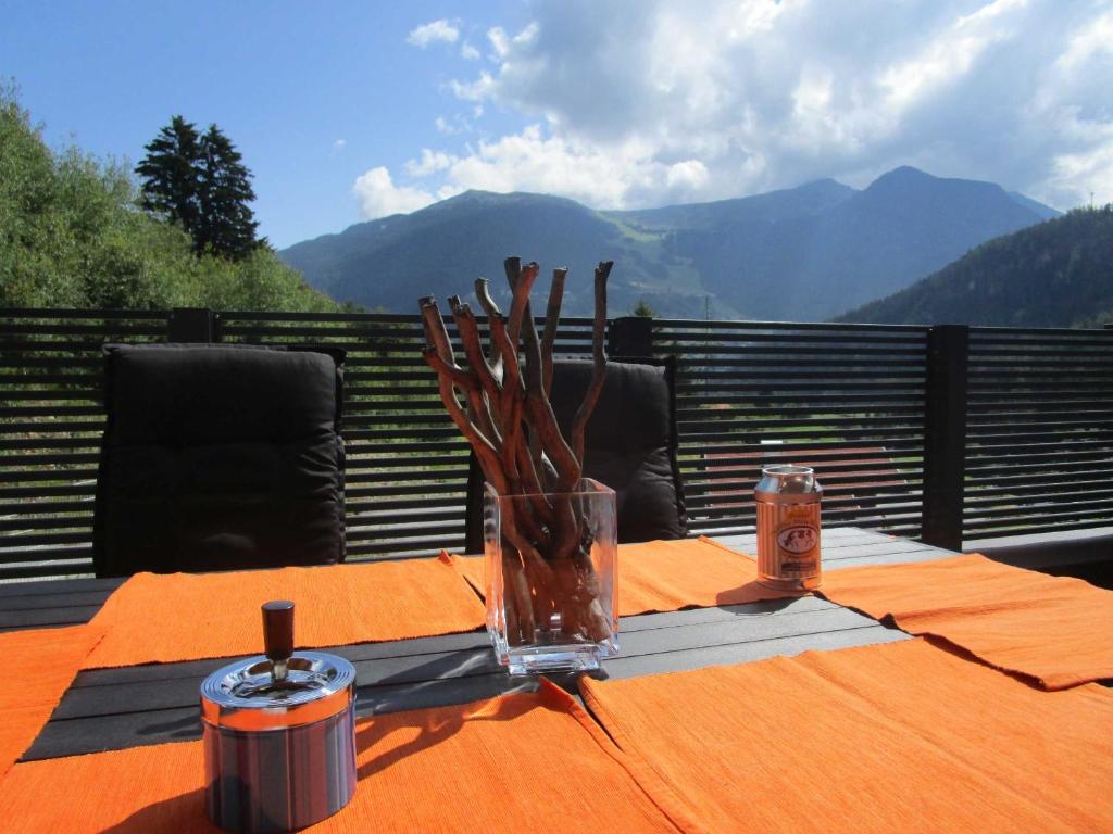 a table with a vase on a table with a view of mountains at Apartment Skyline in Wenns