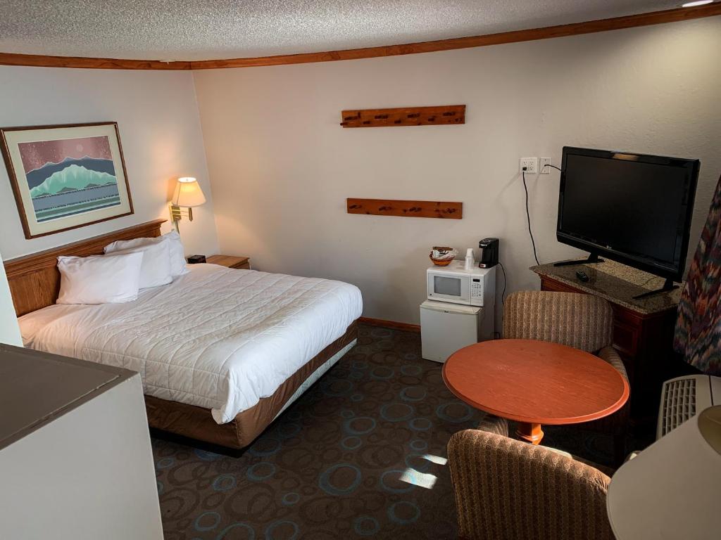 マンモス・レイクスにあるVentura Grand Innのベッドとテレビが備わるホテルルームです。