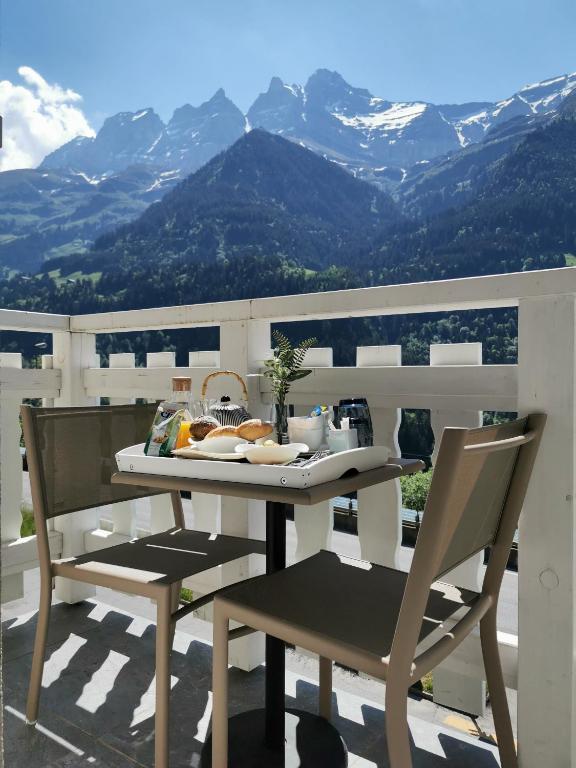 a table and chairs on a balcony with mountains at Hôtel Le White - Le 42 Restaurant in Champéry