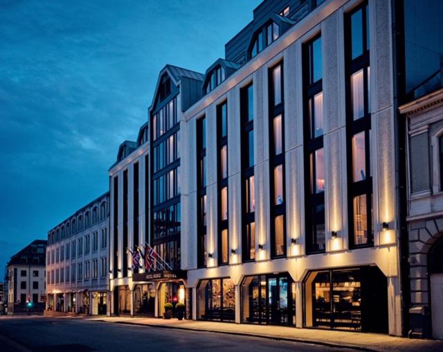 un grand bâtiment situé dans une rue de la ville la nuit dans l'établissement Thon Partner Hotel Norge, à Kristiansand