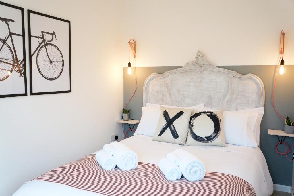 - une chambre avec un lit blanc et des serviettes dans l'établissement The Oldbrook Garden Flat, à Milton Keynes