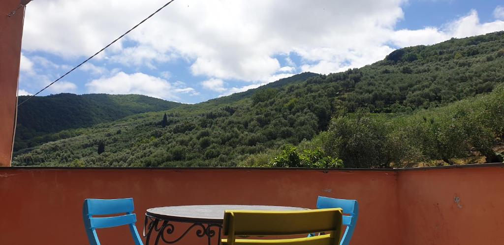 a table and chairs on a balcony with a view of a mountain at Immerso nel Verde in Chiusavecchia