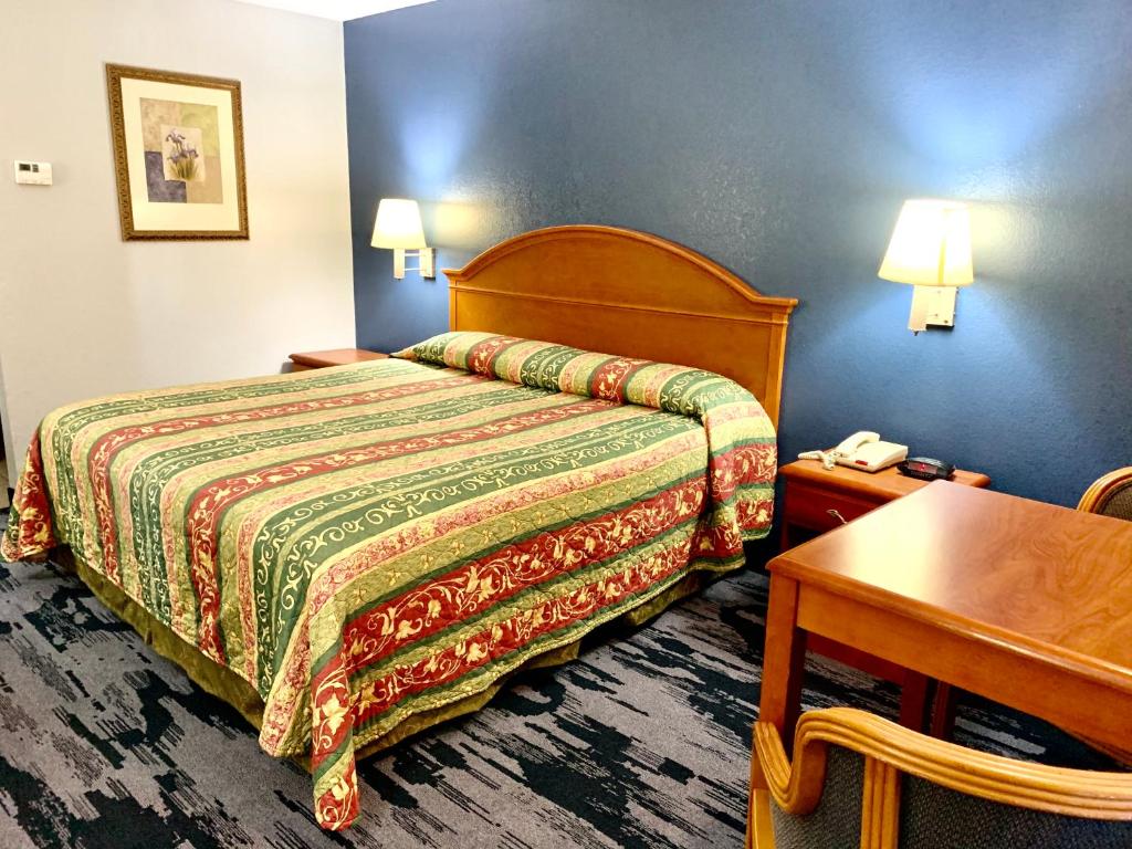 um quarto de hotel com uma cama e uma mesa em Scottish Inns Westcott Street em Houston