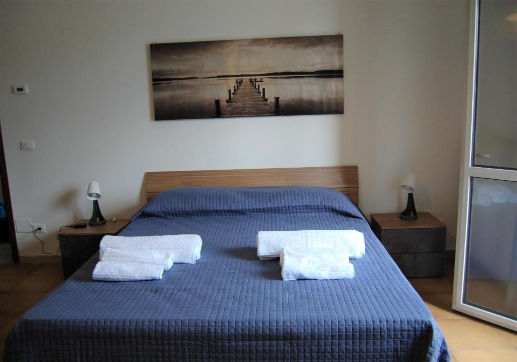 sypialnia z niebieskim łóżkiem i 2 białymi ręcznikami w obiekcie Locazione Turistica Elite Parco Brentelle bed & breakfast - Chiesanuova 135 e 167 w Padwie