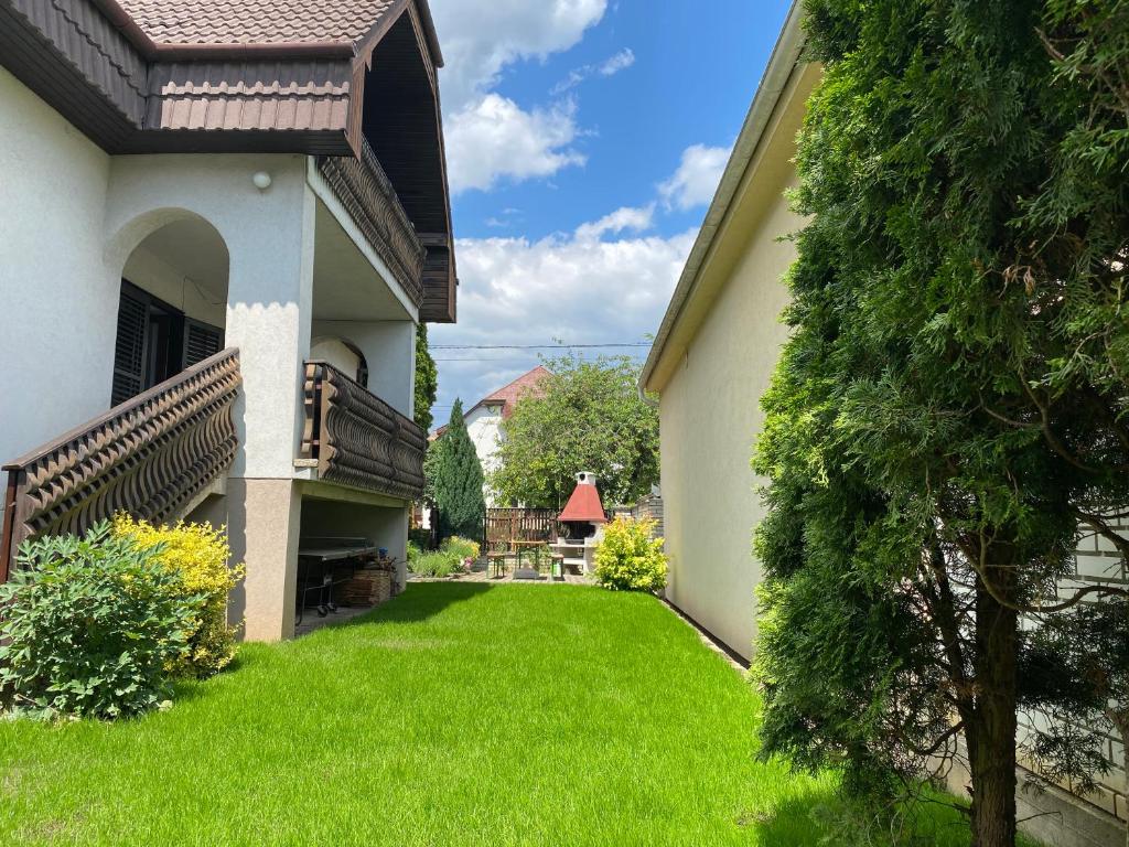 un patio de una casa con césped verde en Szomszéd Ház en Keszthely