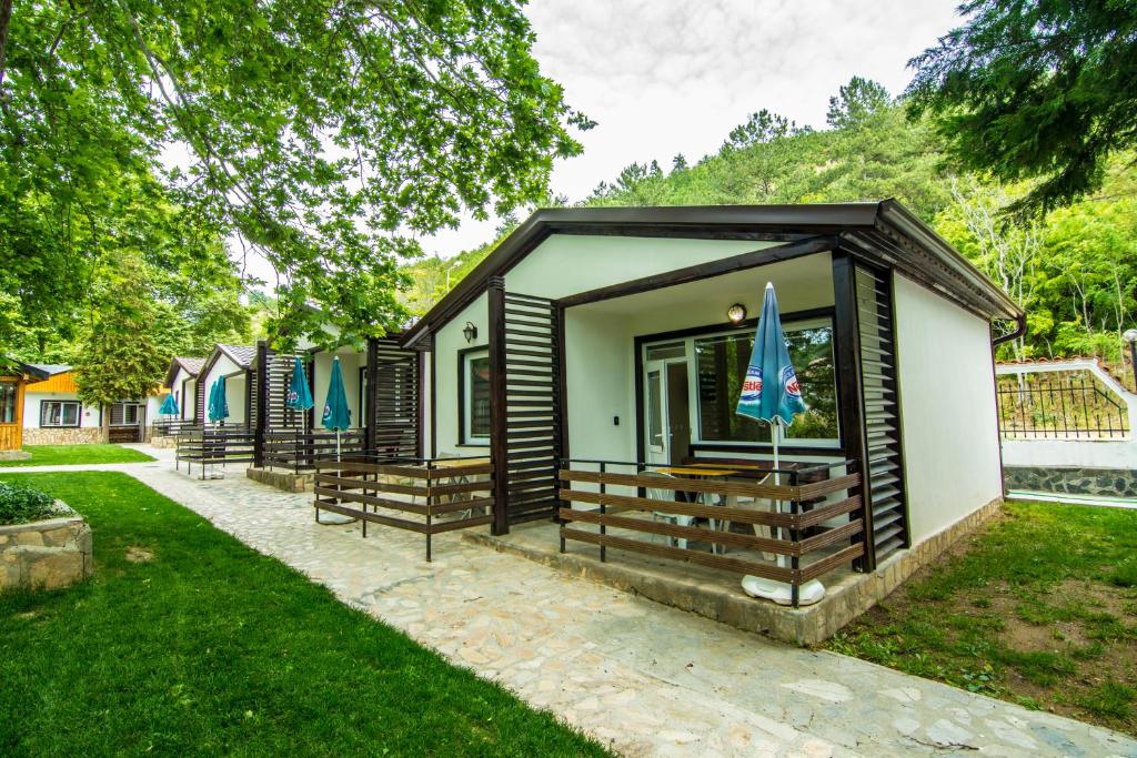 eine kleine Hütte mit Bänken im Gras in der Unterkunft Бунгала Сън Сити in Sandanski