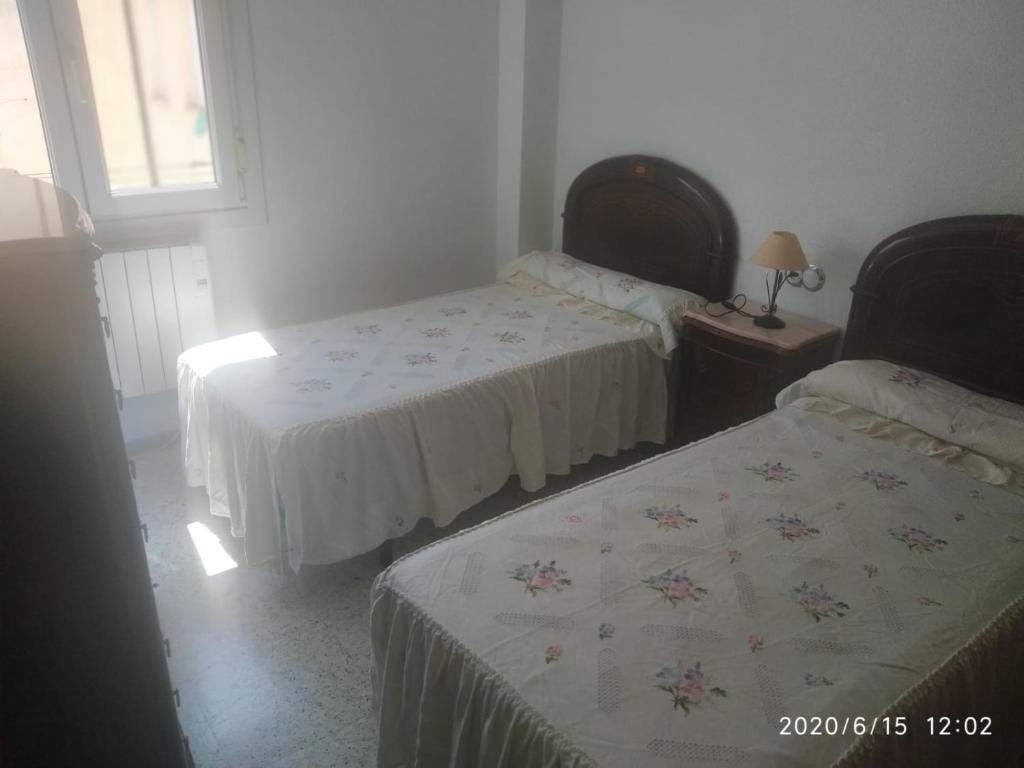 sypialnia z dwoma łóżkami i stołem z lampą w obiekcie La Conchita w mieście Almería