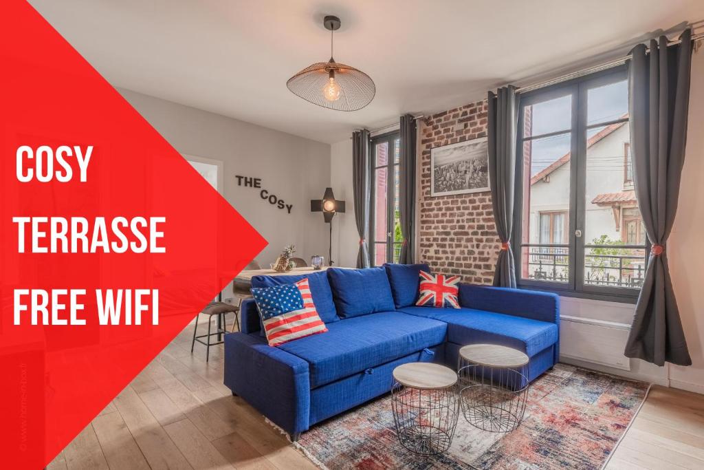 a living room with a blue couch and a red sign at THE COSY in Arcueil