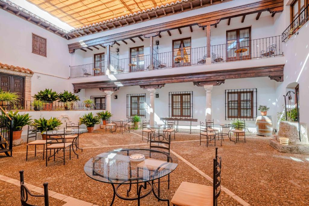 a courtyard with tables and chairs in a building at Hotel Retiro del Maestre in Almagro