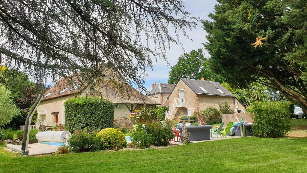 una casa en un patio con un patio en Au Clos du Coteau, Chambres d'Hôtes, en Crotelles