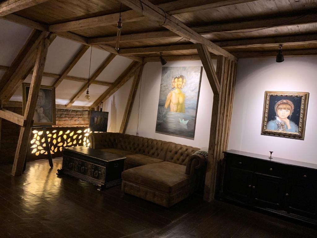 a living room with a couch and paintings on the walls at Gallery Loft in Piatra Neamţ