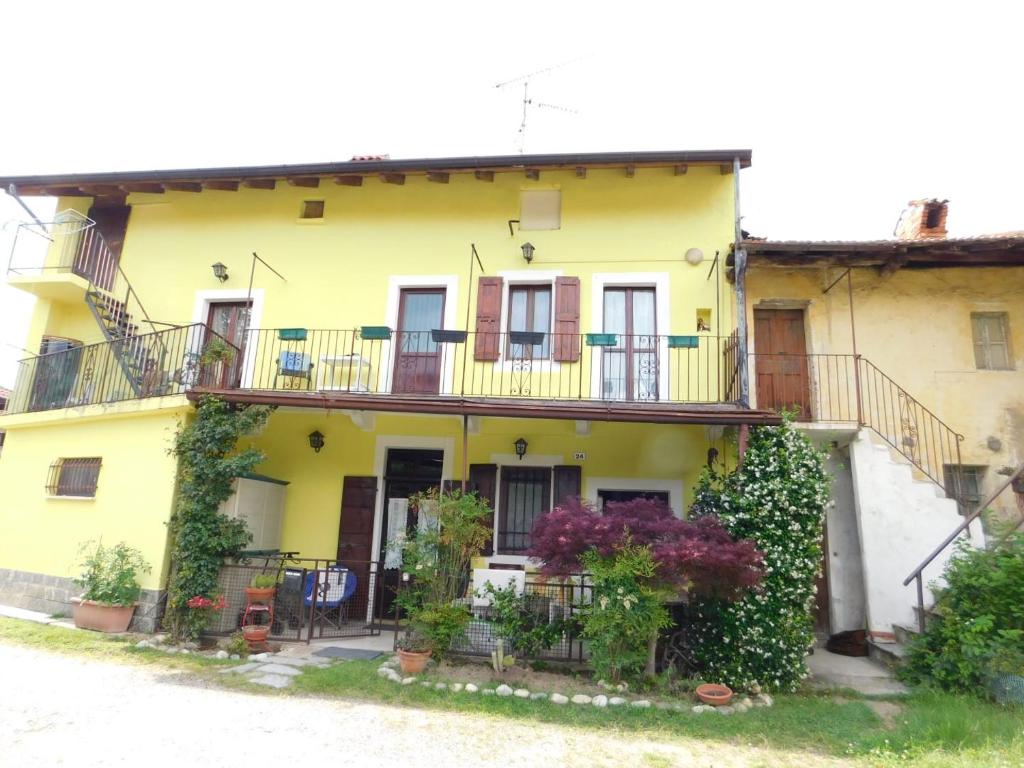 ein gelbes Haus mit Balkonen und Pflanzen darauf in der Unterkunft Appartamento sul lago Maggiore in Castelletto sopra Ticino
