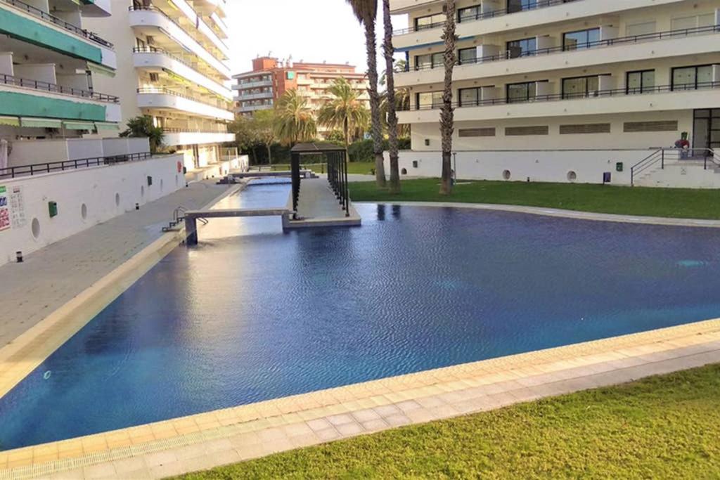 uma grande piscina com parque infantil em frente a um edifício em Apartaments familiar cerca Port Aventura em Salou