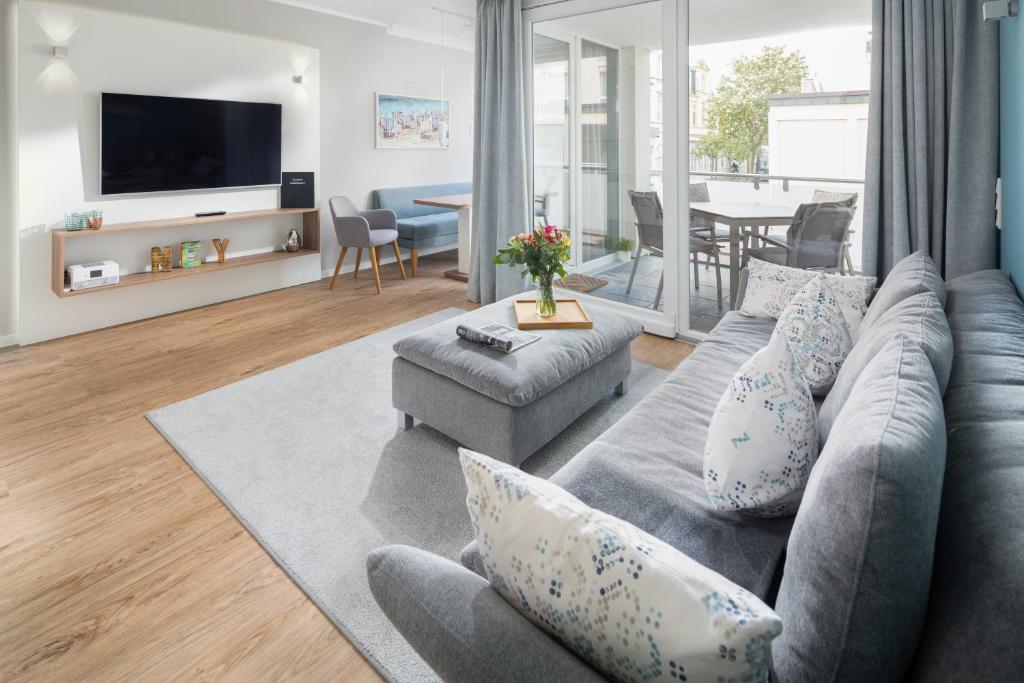 a living room with a gray couch and a table at Düsseldorfer Hof Norderney A1 in Norderney