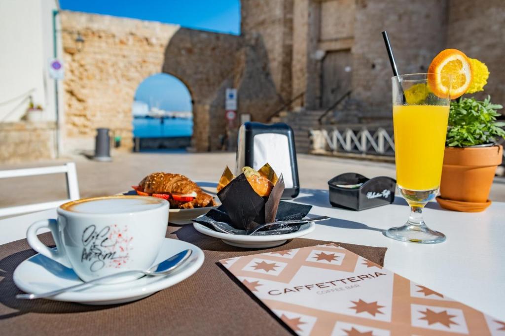 una mesa con una taza de café y un vaso de zumo de naranja en Dimora Pietrabianca, en Monopoli