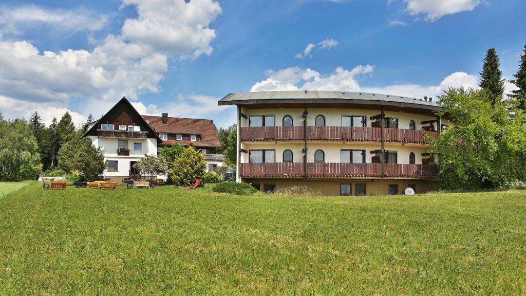 um grande edifício com uma varanda num campo relvado em Hotel Sonnenschein em Freudenstadt