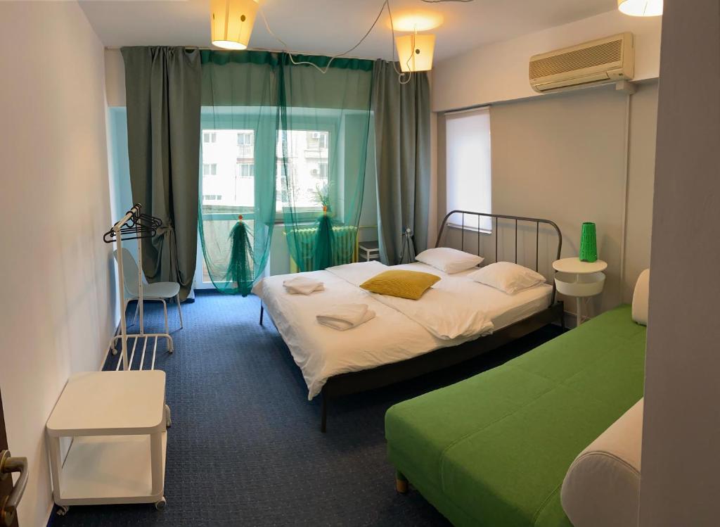 um quarto de hotel com duas camas e uma janela em green Apartment 96 em Bucareste