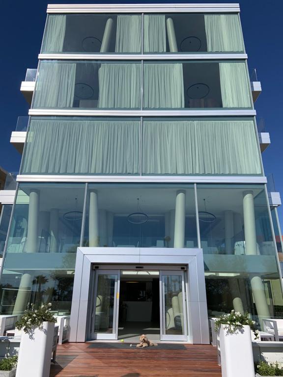 um grande edifício de vidro com uma porta giratória em Hotel Commodore em Cervia