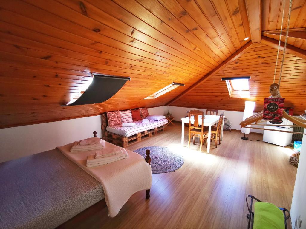 Cette chambre mansardée comprend un lit et une table. dans l'établissement Sintra Central Loft, à Sintra