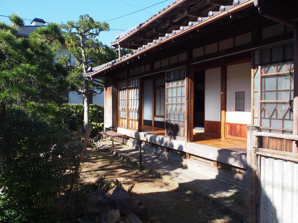 un bâtiment avec un banc devant lui dans l'établissement Guest house SEKINO, à Numazu