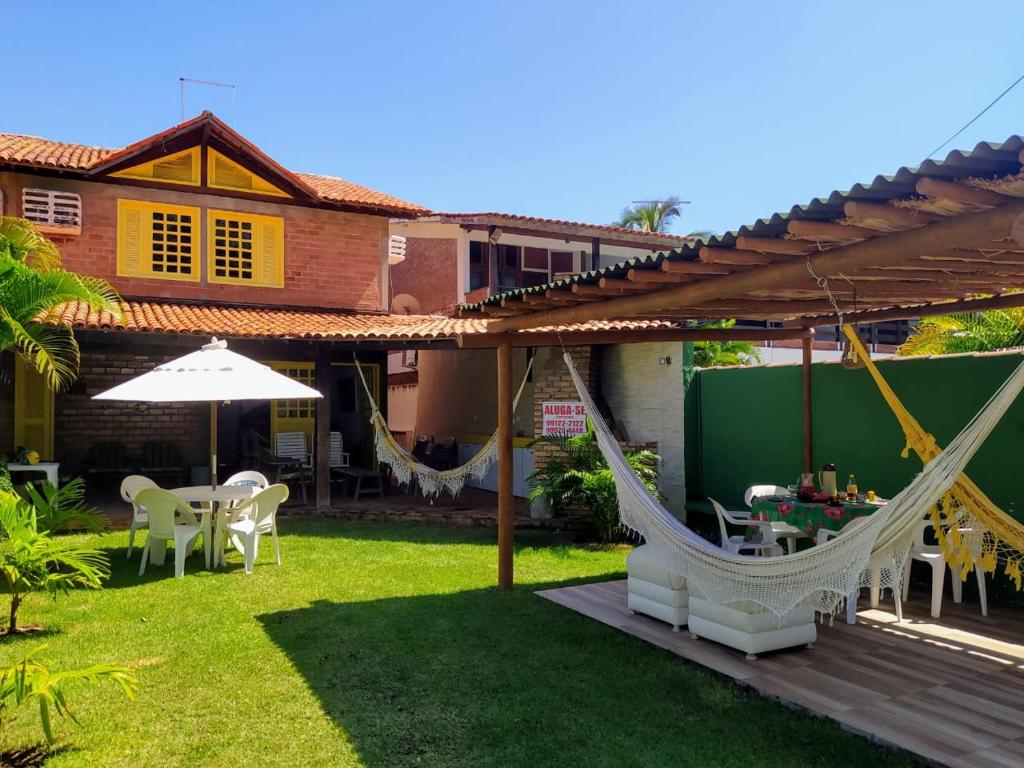 un patio con una hamaca y una casa en Casa Porto de Galinhas, en Porto de Galinhas