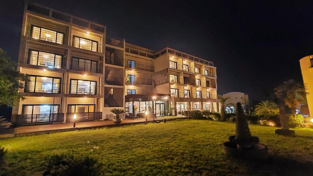 a large building at night with a lawn in front of it at Dombe Resort in Seogwipo