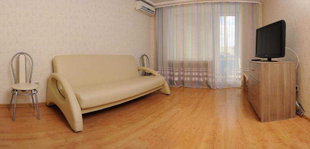 オムスクにあるApartment on Karla Marksa 37のリビングルーム(白い椅子、テレビ付)