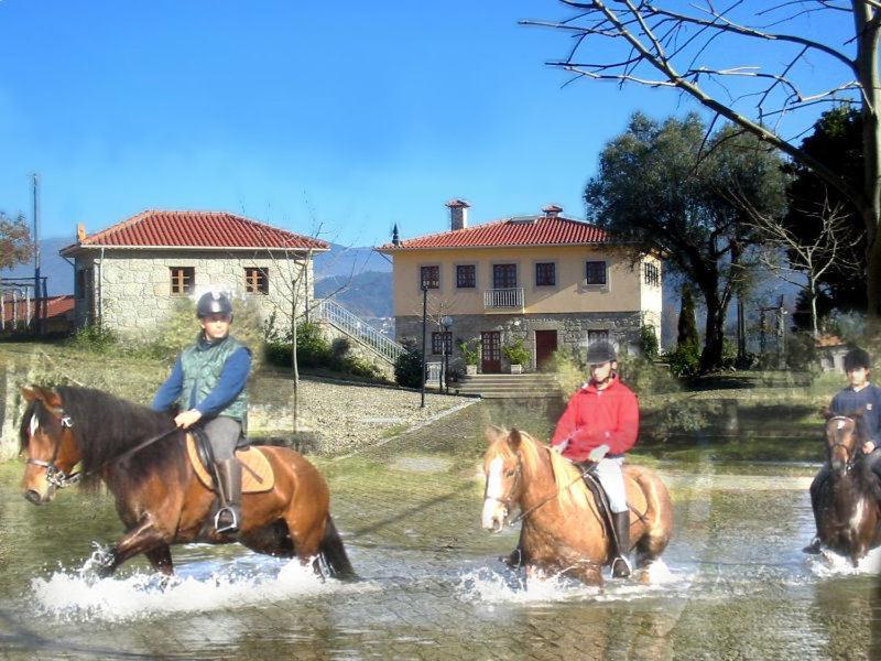 a group of people riding horses through a river at Quinta Do Fijo in Arcos de Valdevez