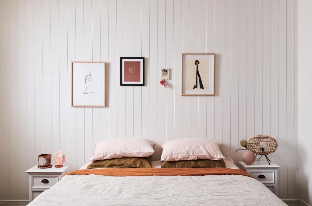 a bedroom with a bed with three pictures on the wall at Anchor Geelong in Geelong