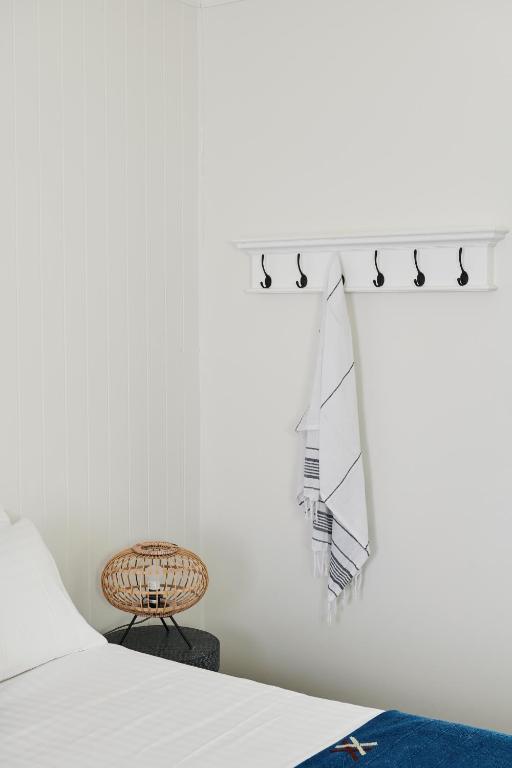 a white bedroom with a bed and a table at Anchor Geelong in Geelong