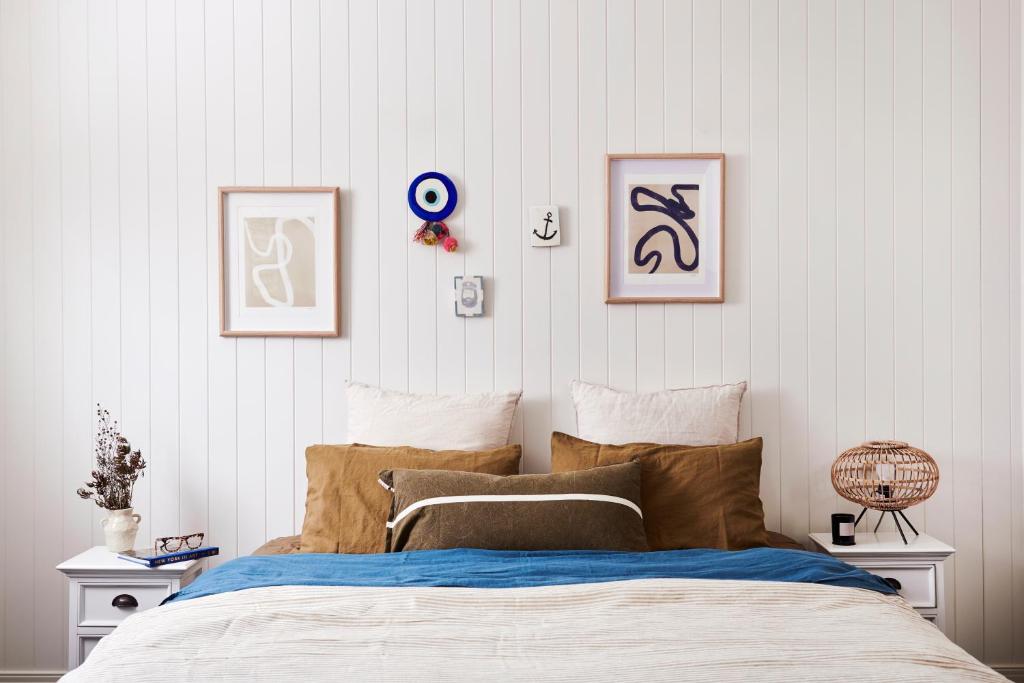 a bedroom with a bed with four pictures on the wall at Anchor Geelong in Geelong