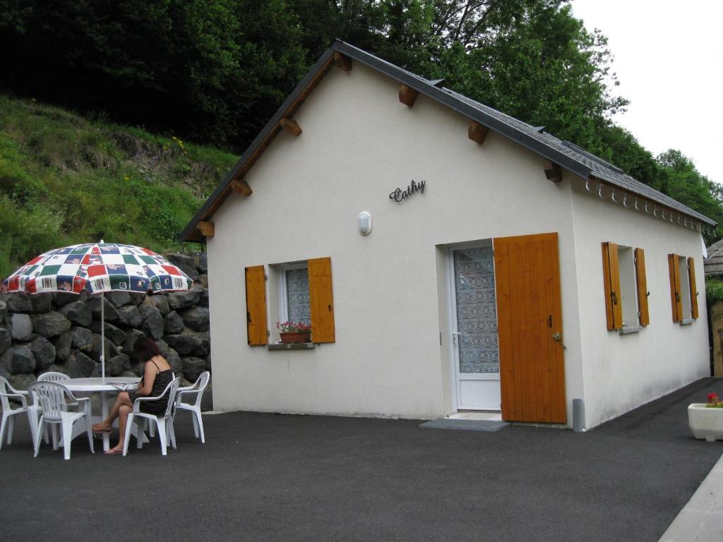 a woman sitting at a table in front of a building at chalet cathy in Laveissière