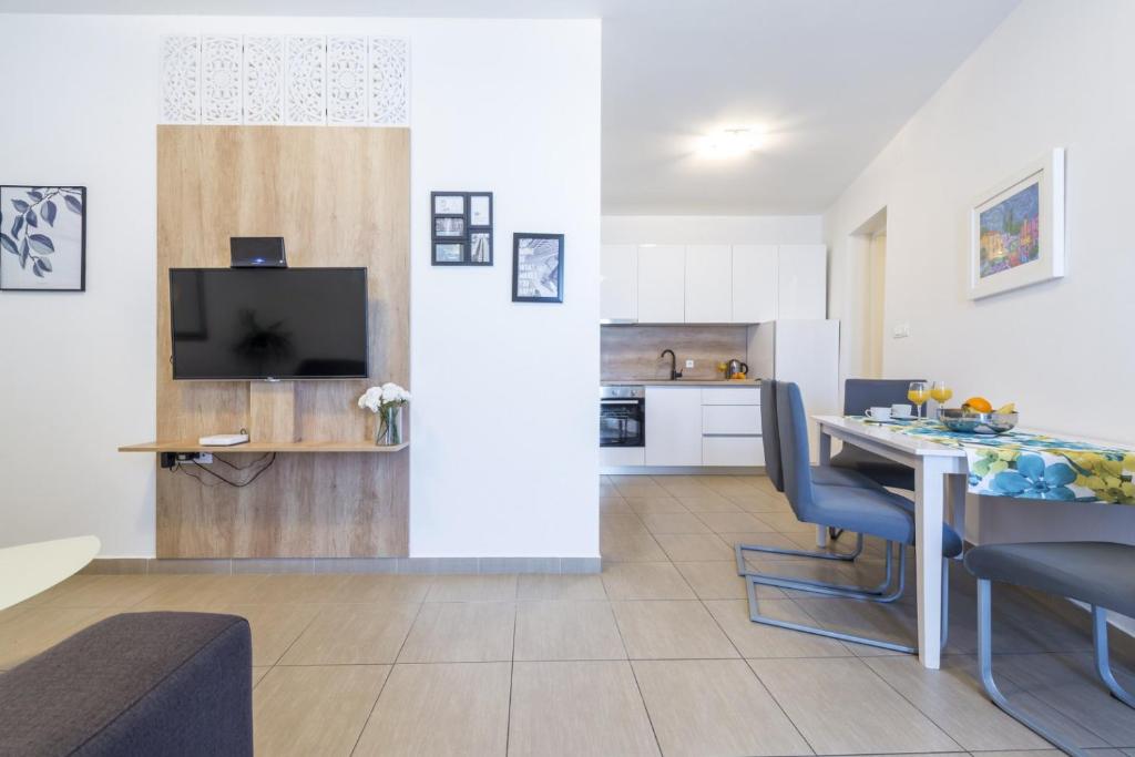 a kitchen and a living room with a table and chairs at Tinker Bell Apartment in Dubrovnik