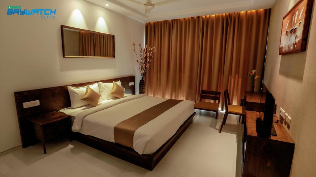 ein Schlafzimmer mit einem großen Bett in einem Zimmer in der Unterkunft Kent Baywatch Suites in Kochi