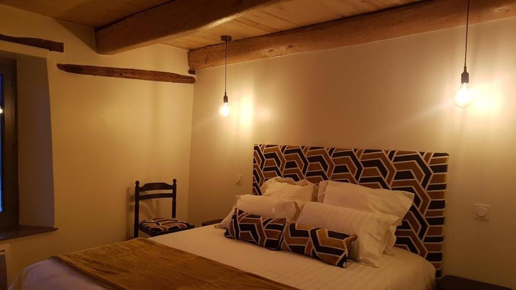 a bedroom with a bed with white sheets and pillows at Chez Francine La Chenevière in Saint-Rémy-de-Chargnat