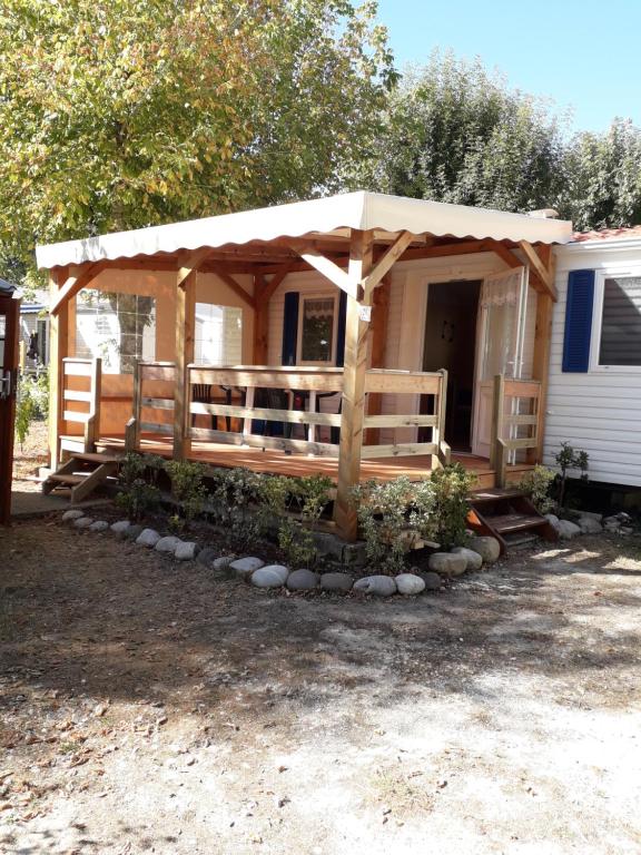 Cette petite maison dispose d'une terrasse couverte avec un toit. dans l'établissement mobil home, à Médis