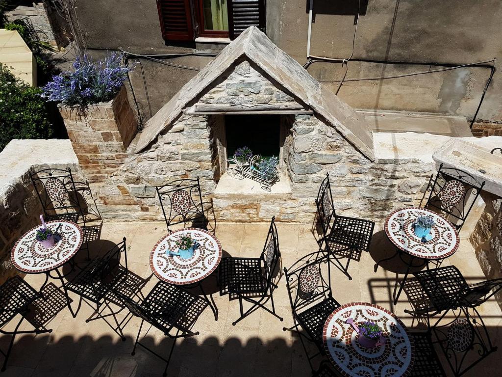 une terrasse avec des tables et des chaises ainsi qu'une cheminée dans l'établissement Villa Nautica Stone House, à Split