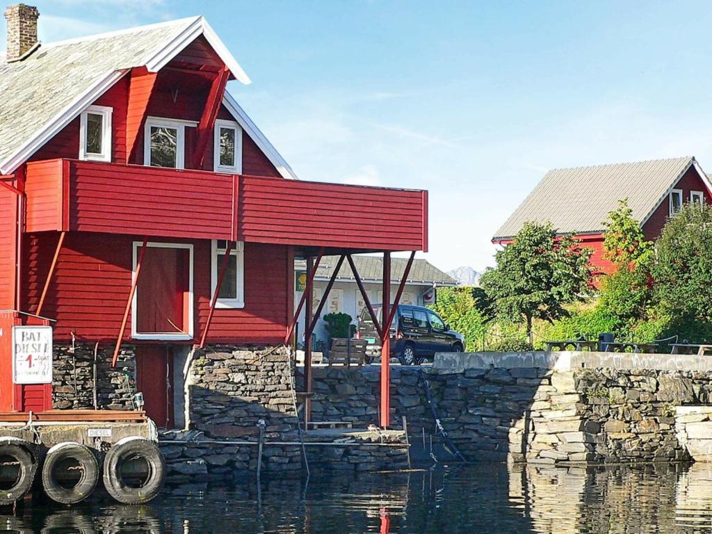 ein rotes Haus neben einem Wasserkörper in der Unterkunft Holiday Home Sørbøvåg II in Sørbø