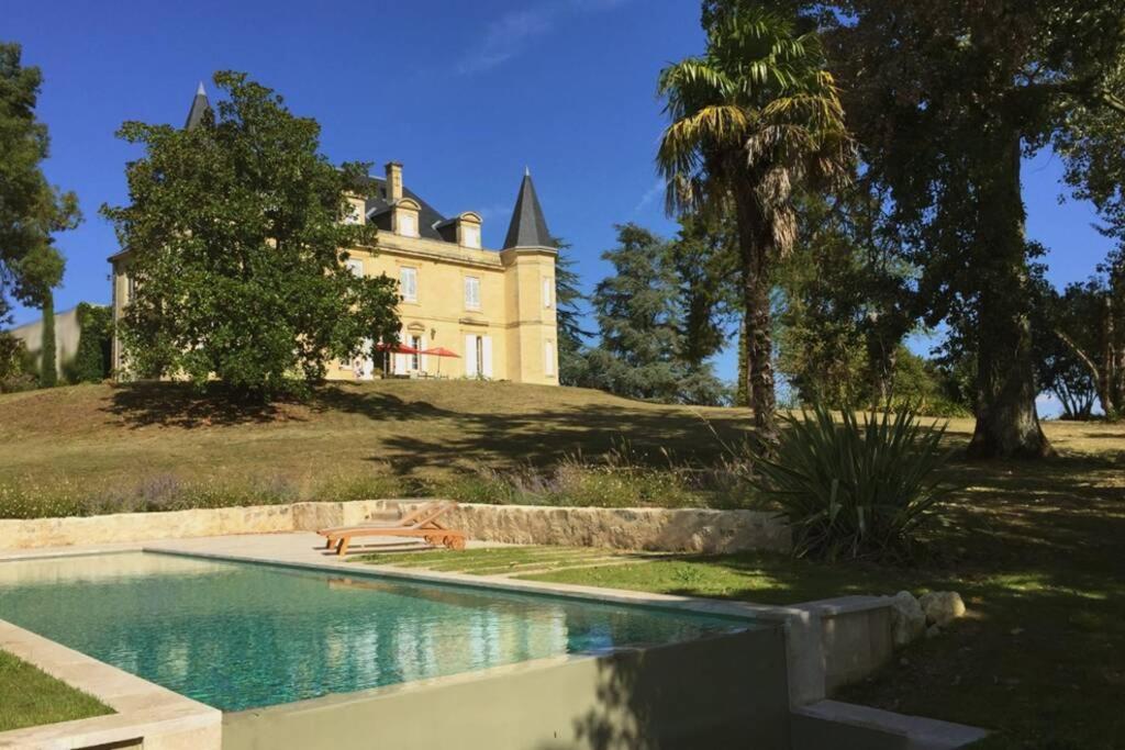 a house sitting on top of a hill with a swimming pool at Château du Grava in Haux