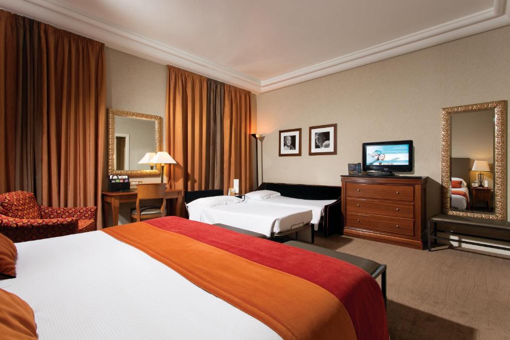 ein Hotelzimmer mit 2 Betten und einem TV in der Unterkunft Hotel dei Mellini in Rom