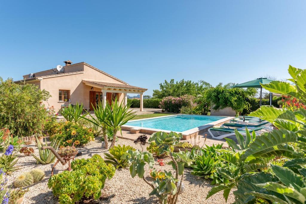 a villa with a swimming pool in a garden at S'hortet in Alcudia
