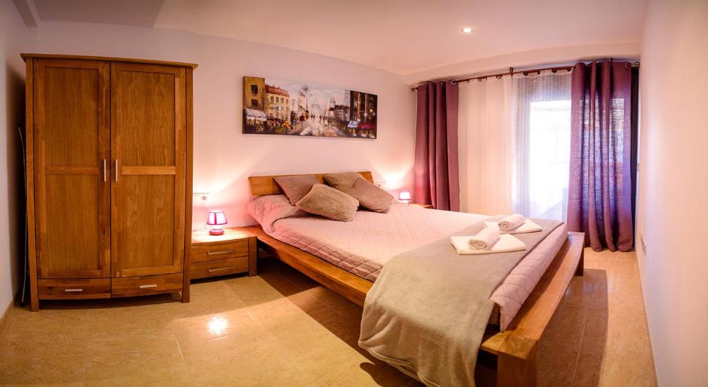 a bedroom with a bed and a cabinet and a window at Parrot’s House in Lloret de Mar