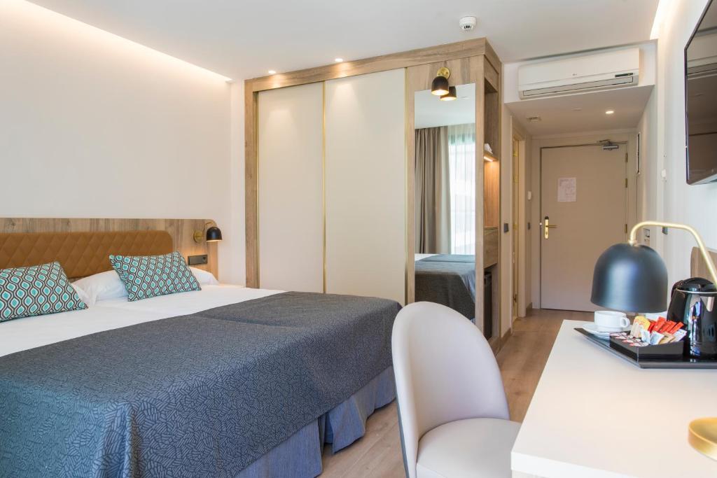 pokój hotelowy z łóżkiem i stołem w obiekcie Hotel Presidente 4 sup w mieście Benidorm