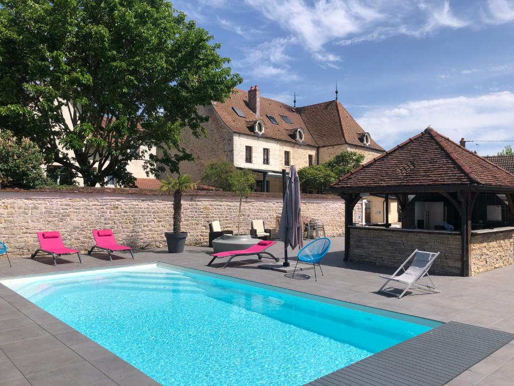 a swimming pool with chairs and a gazebo at Logis L'Hôtel D'Arc in Arc-sur-Tille